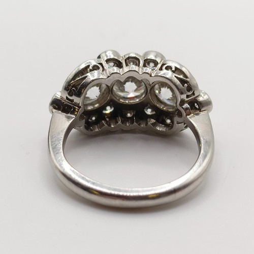 954 - A platinum and diamond ring, with three diamonds within a surround of further diamonds in a rising a... 