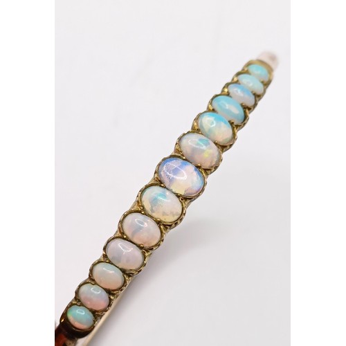 966 - A gold and opal higned bangle