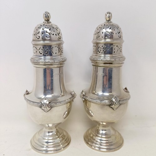 1085 - A pair of 18th century style silver sugar casters, with flowerhead finials, Birmingham 1925, 26.6 oz... 