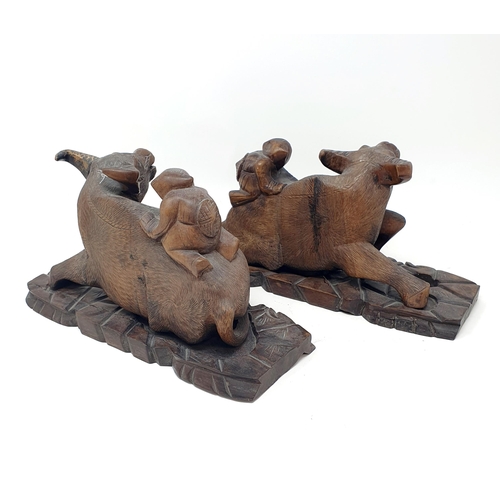 1452A - A pair of Chinese carvings of oxen, with figures on their backs, 30 cm wide (2)