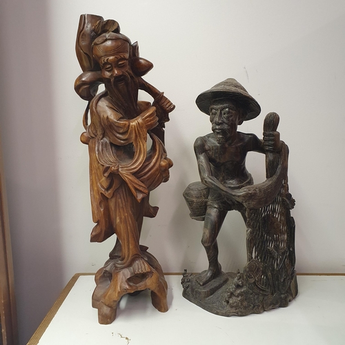 807 - A Chinese carving of a figure, converted to a lamp base, 55 cm high, and an Eastern carving of a fig... 