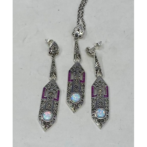 505 - A silver, ruby and opal Art Deco style pendant, on a chain, and matching earrings (3)