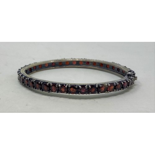 559 - A silver and garnet bangle