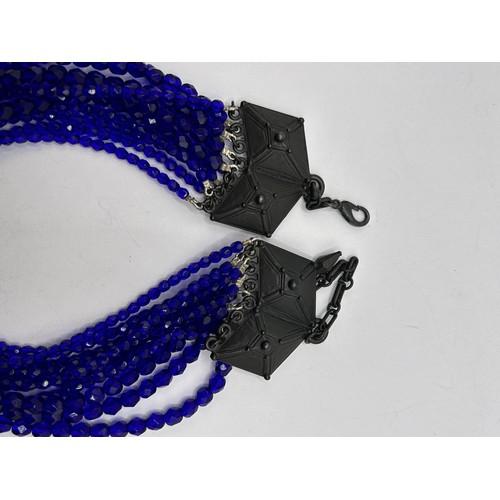 581 - A Jean Paul Gaultier blue bead triple thread necklace, with a cross pendant