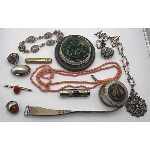 629 - A carved green stone bangle, a coral necklace, a novelty tape measure, decorated owl, and other item... 