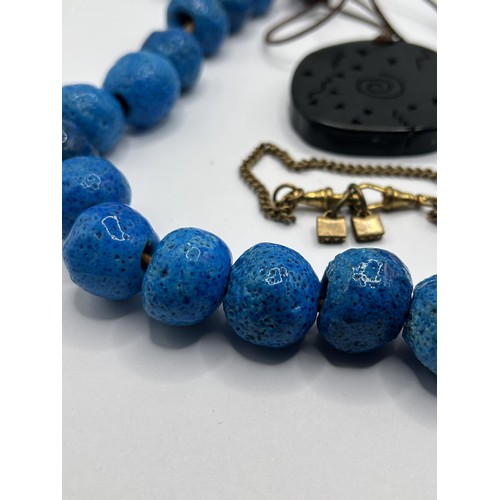 635 - ***On instructions of the family regretfully withdrawn*** A ceramic blue bead necklace, and a pendan... 