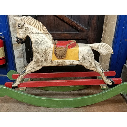 759 - A vintage painted wooden rocking horse, 144 cm wide