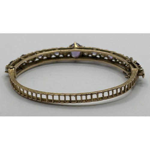 595 - A gold, cultured pearl and amethyst hinged bangle