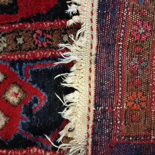 957 - A Turkey style red ground rug, 153 cm wide