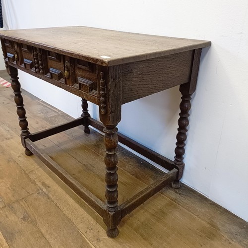 1008 - An oak side table, with a carved frieze drawer, on bobbin turned legs united by a stretcher, 90 cm w... 