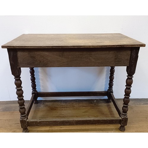 1008 - An oak side table, with a carved frieze drawer, on bobbin turned legs united by a stretcher, 90 cm w... 