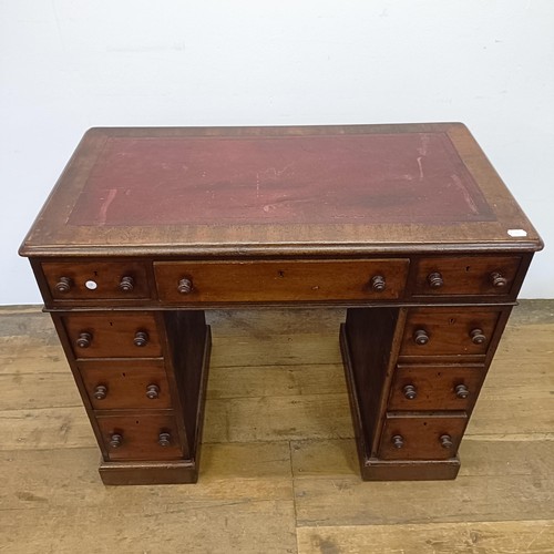 1014 - A mahogany pedestal desk, of small proportions, with an inset top above nine drawers, 92 cm wide