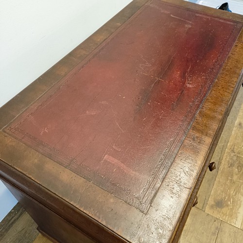 1014 - A mahogany pedestal desk, of small proportions, with an inset top above nine drawers, 92 cm wide