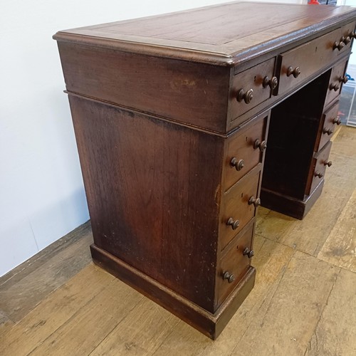 1014 - A mahogany pedestal desk, of small proportions, with an inset top above nine drawers, 92 cm wide