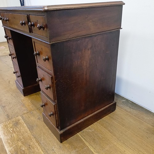 1014 - A mahogany pedestal desk, of small proportions, with an inset top above nine drawers, 92 cm wide