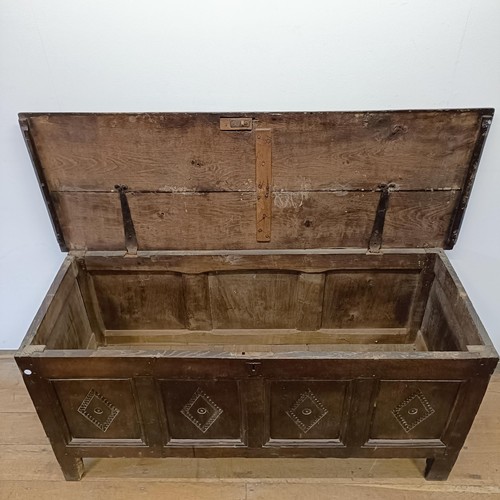 1026 - An 18th century oak coffer, carved lozenges, on stile legs, 140 cm wide