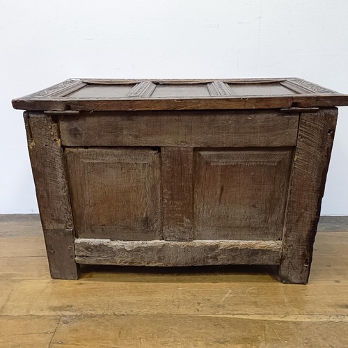 1027 - An 18th century oak coffer, with carved decoration, on stile legs, 84 cm wide