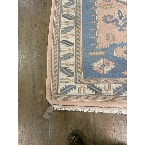 1061 - A Turkish pink ground rug, 245 x 196 cm