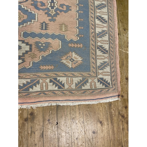 1061 - A Turkish pink ground rug, 245 x 196 cm