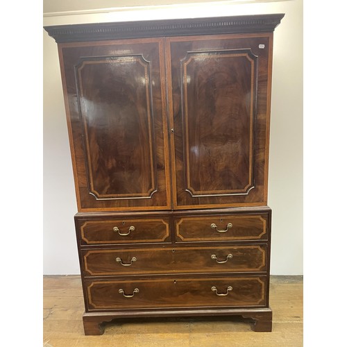 1003 - A late 19th/early 20th century inlaid mahogany linen press, the top with two cupboard doors, to reve... 