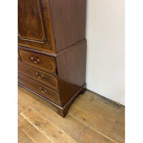 1003 - A late 19th/early 20th century inlaid mahogany linen press, the top with two cupboard doors, to reve... 