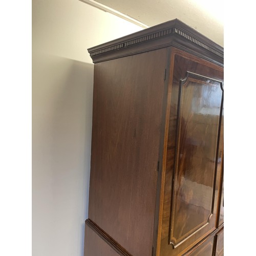 1003 - A late 19th/early 20th century inlaid mahogany linen press, the top with two cupboard doors, to reve... 