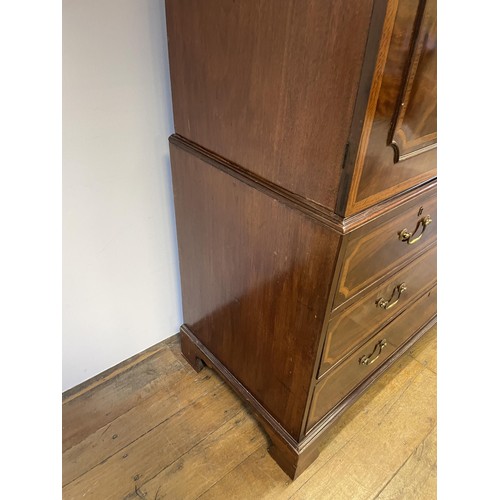 1003 - A late 19th/early 20th century inlaid mahogany linen press, the top with two cupboard doors, to reve... 