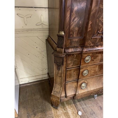 998 - An 18th century Dutch armoire, with two cupboard doors to reveal shelf and drawers, on a base with t... 