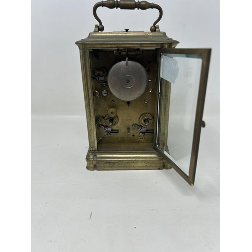 903 - A carriage clock, with a repeat and an alarm, in a brass and glass case, 16 cm high