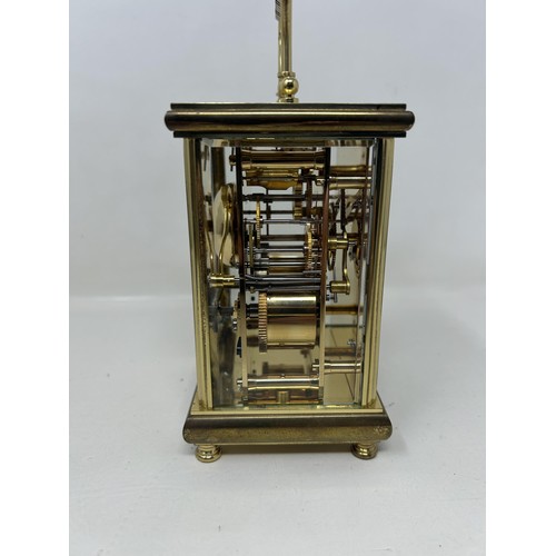 905 - A carriage clock, in a brass and glass case, 56 cm high