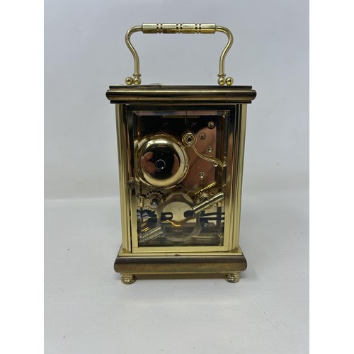 905 - A carriage clock, in a brass and glass case, 56 cm high