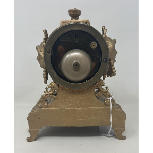 891A - A mantel clock, with a porcelain dial, with a twin train 8 day movement, in a gilt metal case, 20 cm... 