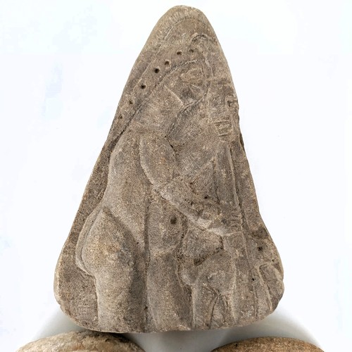 825 - A carved stone, of triangular form, decorated a figure, 22 cm high, and two other stone carvings (3)