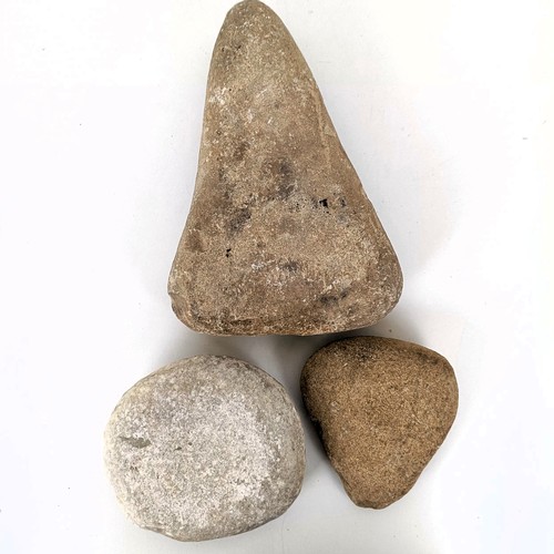 825 - A carved stone, of triangular form, decorated a figure, 22 cm high, and two other stone carvings (3)