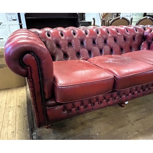 975 - A Chesterfield style red leather sofa, 213 cm wide