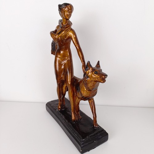 803 - An Art Deco style figure, of a lady with an Alsatian, 35 cm high, an Art Nouveau style brass pin tra... 