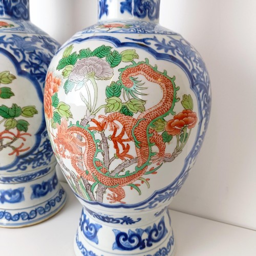 805 - A pair of Chinese blue and white vases, the central cartouche decorated with dragons, 47 cm high (2)