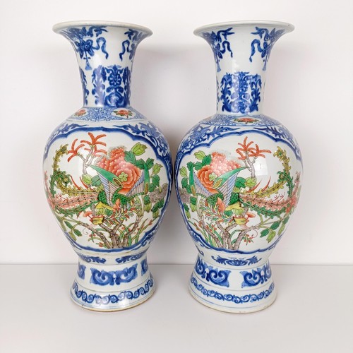 805 - A pair of Chinese blue and white vases, the central cartouche decorated with dragons, 47 cm high (2)