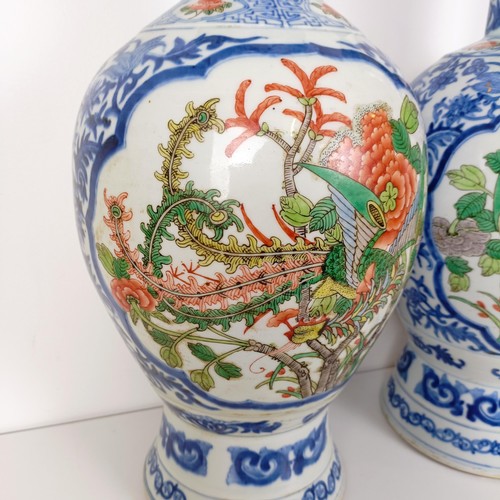 805 - A pair of Chinese blue and white vases, the central cartouche decorated with dragons, 47 cm high (2)