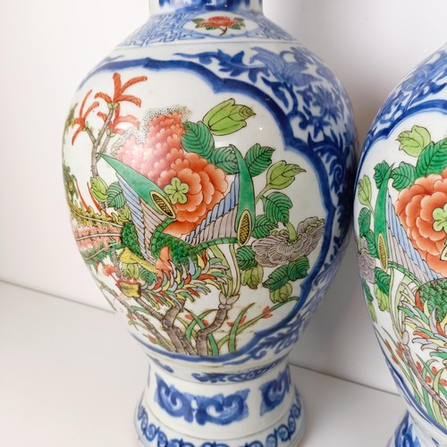 805 - A pair of Chinese blue and white vases, the central cartouche decorated with dragons, 47 cm high (2)