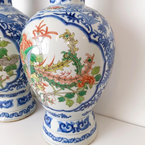 805 - A pair of Chinese blue and white vases, the central cartouche decorated with dragons, 47 cm high (2)