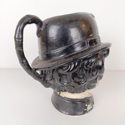 810 - An unusual character jug, in the form of Charlie Chaplin, 23 cm high, handle repaired