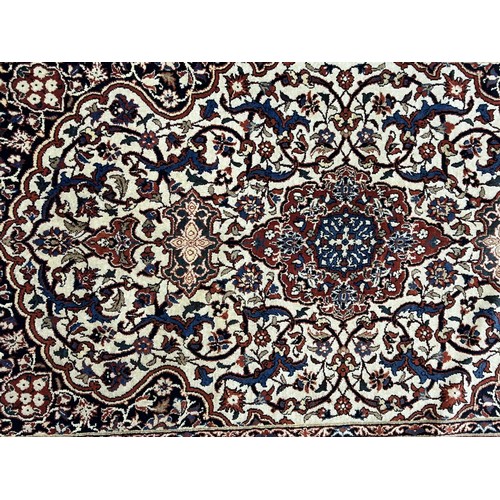 981 - A Persian cream ground rug, with multiple borders, the centre with a shaped medallion and repeating ... 