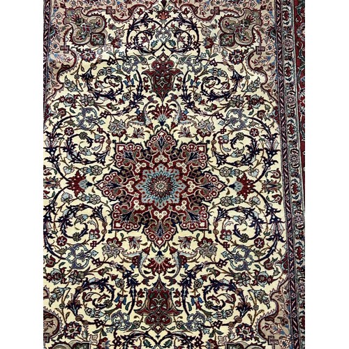 980 - A Persian cream ground rug, with multiple borders, the centre with concentric shaped medallions, sur... 