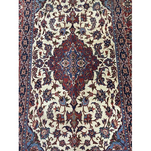 979 - A Persian cream ground rug, with multiple borders, the centre with shaped concentric medallion, surr... 