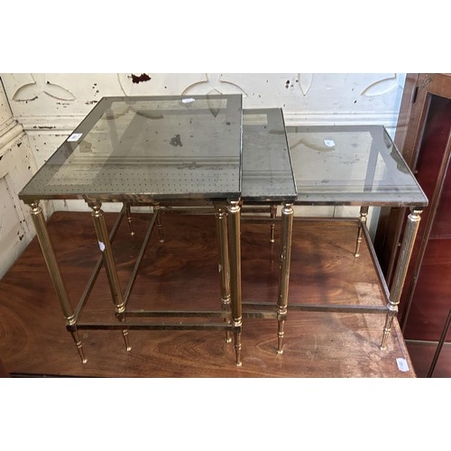 936 - A nest of three brass tables, with glass tops, 53 cm wide