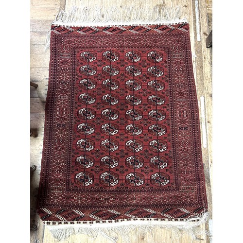 978 - An Afghan type red ground rug, the centre with multiple repeating medallions, 167 x 120 cm