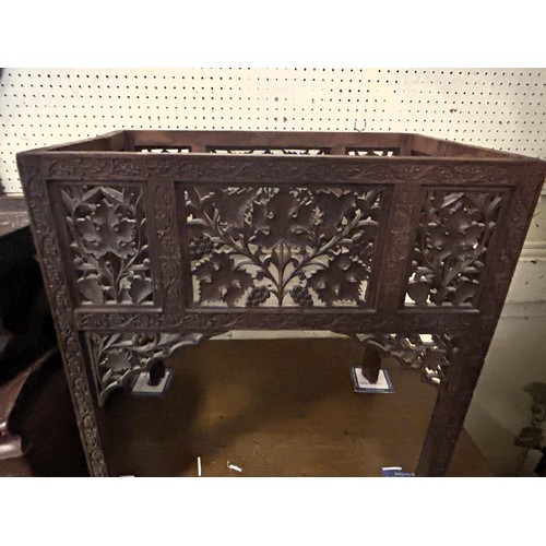 971 - A carved Eastern folding table, decorated repeating foliate forms, 62 cm wide