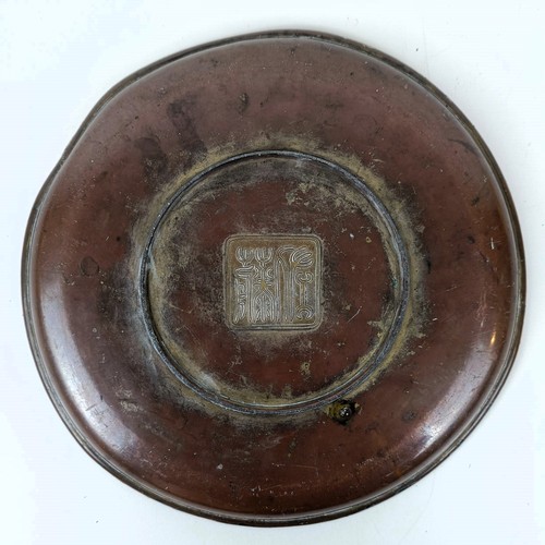 811 - A Japanese gilt metal dish, decorated fighting warriors, 25 cm diameter