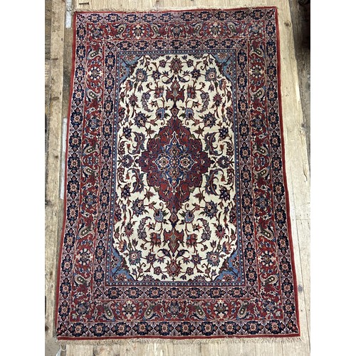 731 - A Persian cream ground rug, with multiple borders, the centre with shaped concentric medallion, surr... 